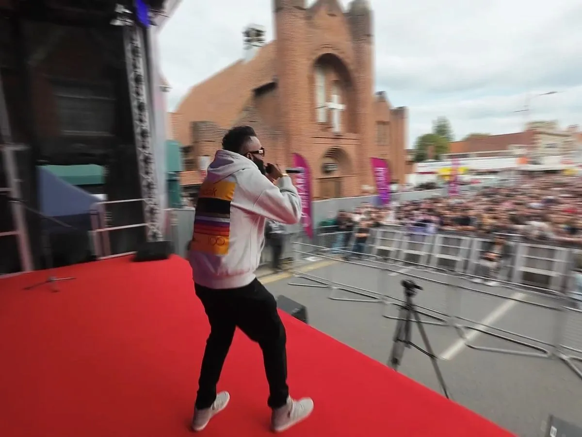 FPV shot of a performer on stage in front of a festival crowd