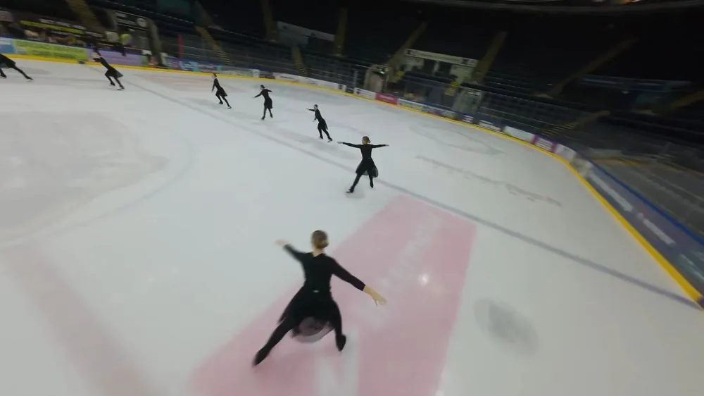 FPV following synchronised ice skaters in an arena